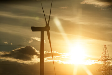 Fototapeta na wymiar Wind turbine on the sunset. Blue energy.