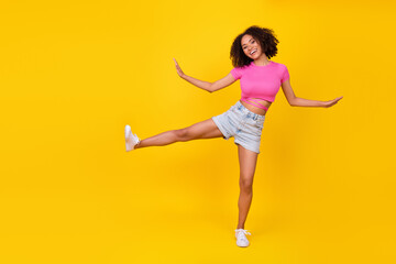 Fototapeta na wymiar Full size portrait of carefree crazy person raise one leg enjoy free time dance isolated on yellow color background
