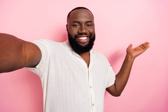 Photo of charming cute guy dressed white shirt recording self video inviting you come empty space isolated pink color background