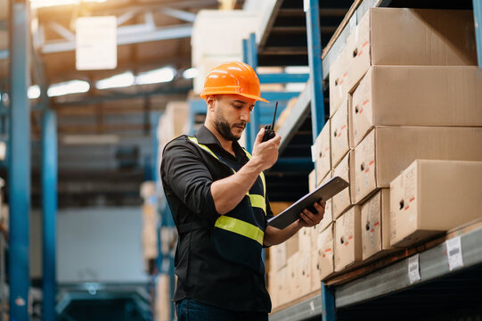 Storage worker in uniform and notepad,digital tablet in hands checks production. warehouse concept