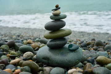 Fototapeta na wymiar Stones stacked one by one, balancing rocks on the seashore
