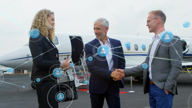 Animation of network of profile icons over diverse businesspeople shaking hands at the airport
