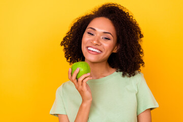 Photo of cheerful positive lady wear green t-shirt eating apple white teeth empty space isolated...