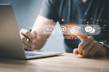 Businessman using a laptop and touching on virtual screen  email, address, live chat, internet wifi icons. Communication and Contact us or Customer support hotline people connect.