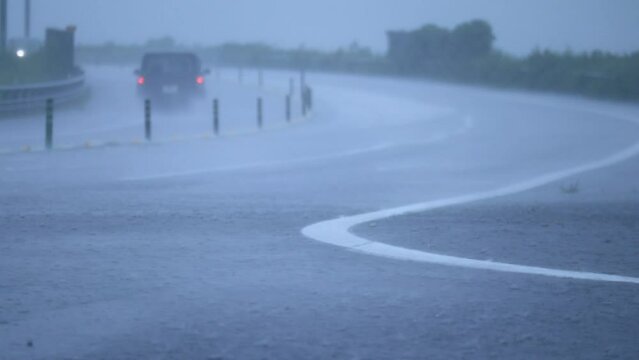 土砂降りの中で走行する自動車　大雨　暴風雨