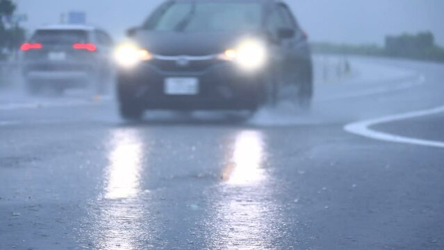 土砂降りの中で走行する自動車　大雨　暴風雨