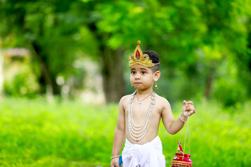 happy Janmashtami Greeting Card showing Little Indian boy posing as Shri krishna or kanha/kanhaiya...