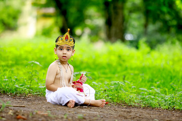 happy Janmashtami Greeting Card showing Little Indian boy posing as Shri Krishna or kanha or...