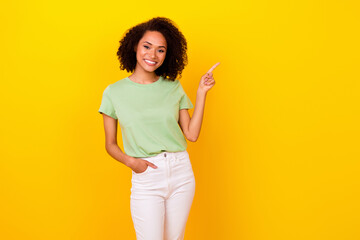 Photo of nice brunette curly lady index promo wear t-shirt pants isolated on bright yellow color background