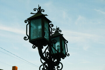 Fototapeta na wymiar Old vintage street lamps against the sky. Beautiful street lights with decorations