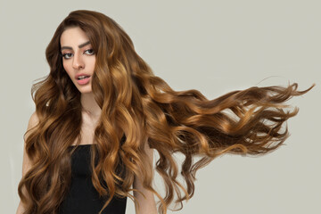 Beautiful fashionable woman with long curly big curls flying up. Hairstyle and makeup