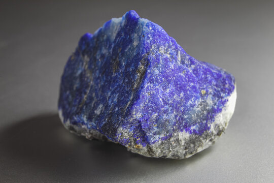 Raw Lapis lazuli rock on white background. Unpolished chunk of lapis lazuli sitting on white background.
Lapis lazuli with Pyrite spots .
Rock with gold details