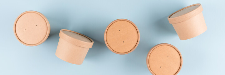 Eco paper food containers - takeaway soup or ice cream containers. Banner with paper cups over light blue background, mockup image. Sustainable food packaging concept