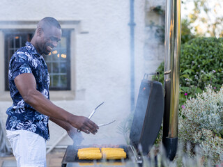 Man grilling corn on barbecue grill