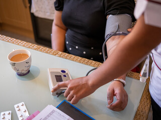 Nurse�visiting mature woman at her house, measuring blood pressure