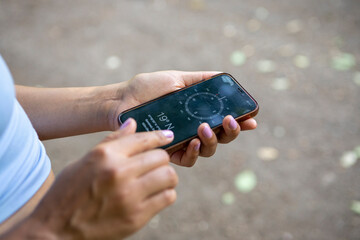 Young woman using compass on smart phone, close up of hands