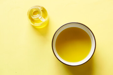 olive oils in a bowl on yellow background 