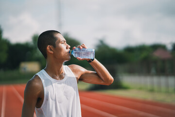sport man hold bottle water runner tired and thirsty after running workout drinking water. Sport man concept.