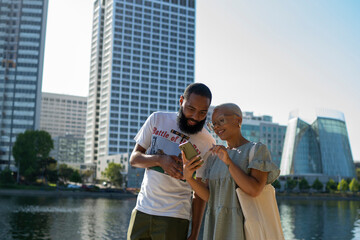Man and woman using smart phone in city in summer © Cultura Creative