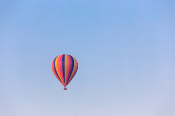 Colorful hot air balloon flying in the bright blue sky