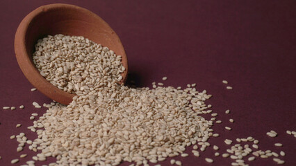  white sesame seeds, sesame seeds in a wooden spoon on an old rustic background close-up