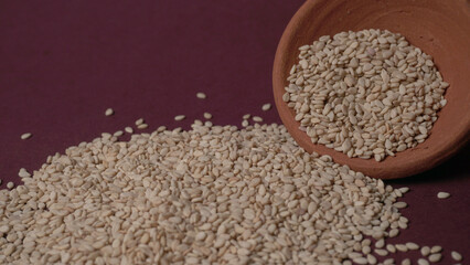  white sesame seeds, sesame seeds in a wooden spoon on an old rustic background close-up