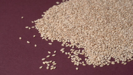  white sesame seeds, sesame seeds in a wooden spoon on an old rustic background close-up