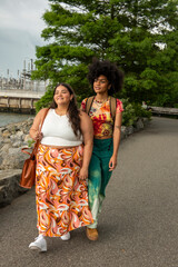 USA, New York City, Two young women walking by river