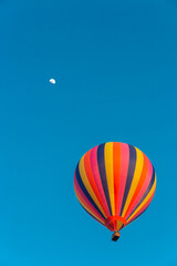 Colorful hot air balloon flying in the bright blue sky