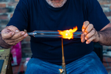 Artigiano del vetro forgia con la fiamma
