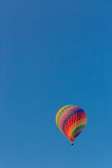 Colorful hot air balloon flying in the bright blue sky