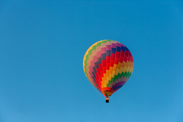 Colorful hot air balloon flying in the bright blue sky