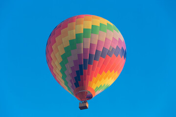 Colorful hot air balloon flying in the bright blue sky