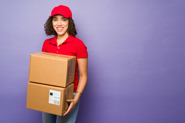 Young happy woman holding packages and working in delivery service