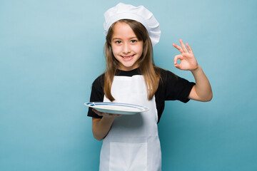 Talented girl cooking good food against a blue background