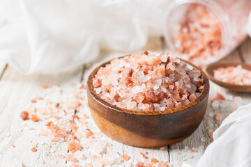 Fototapeta na wymiar Himalayan salt or pink salt is placed in a cup on a white table.