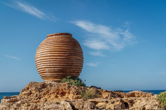 Crete island, Greece. Ancient amphora Koronios by the sea &ndash; decoration in Potamos beach, Malia near Chersonissos. Travel vacation concept.