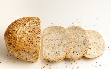 Fresh Multigrain artisan round Bread with crumbsliced, cutted wheat bread or bun with sesame and flax seeds Isolated on White Background. Food concept.