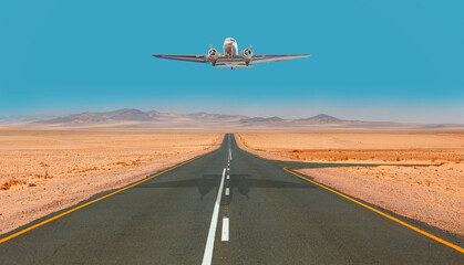 Vintage airplane with propeller flying over an empty asphalt road - National Park empty asphalt road  - Namib desert, Africa
