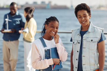 Waist up portrait of two black teenagers smiling at camera during outdoor class in sunlight, copy space