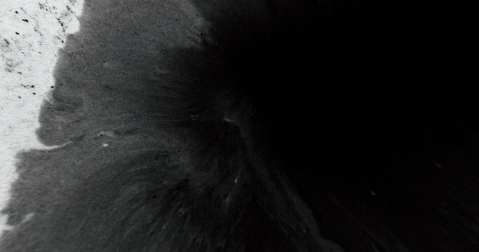 Black ink water drop. Reveal transition. Cover overlay. Wet paint stain spatter flow on white dust texture creative abstract empty space background.