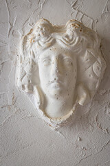 Stone carving of a face, on wall. 