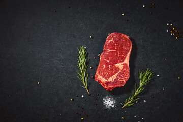 Top view fresh red raw meat with spice and salt. Beef steak on a dark table flat lay copy space background