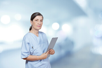 Portrait of a stern looking middle aged nurse in a blue scrub holding a clipboard, hospital interior background, blue filter effect.