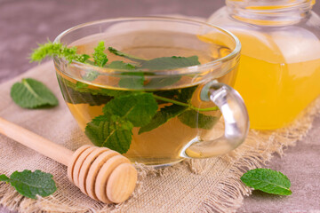 Mint tea with honey in a transparent cup.Close-up.
