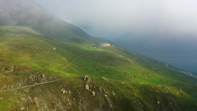Aerial Forward Shot Of Fort De Ronce By Mont Cenis Lake During Foggy Weather - Val-Cenis, France