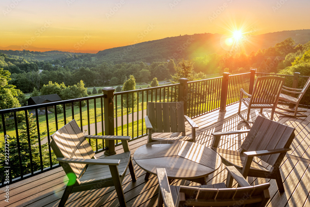 Wall mural beautiful dawn sunshine breaking over hills with wooden balcony