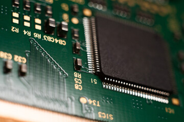 Macro photo of a green computer printed circuit board with selective focus on an blank chip. Concept photo. Microchip manufacturing in Taiwan.