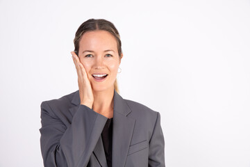 Portrait of confused young businesswoman touching face. Caucasian woman wearing gray suit coat forgetting something or making mistake. Problem or confusion concept