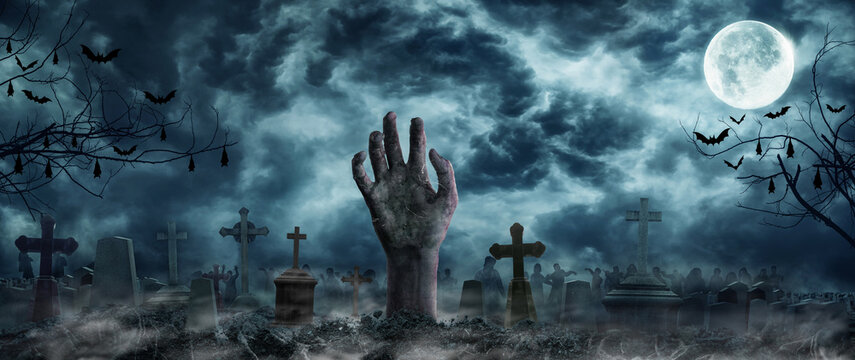 Hand Zombie Rising Out Of A Graveyard cemetery In Spooky scary dark Night full moon bats on tree. Holiday event halloween banner background concept.